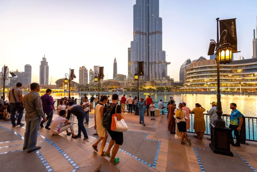 Photograph of tourists enjoying the bustling streets of Dubai, safely exploring the city's attractions under the watchful eyes of the Dubai Police Force.