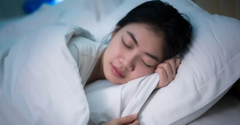 Gambar secangkir teh chamomile di meja samping tempat tidur, menggambarkan penggunaan remedi alami untuk mendukung tidur yang lebih baik.