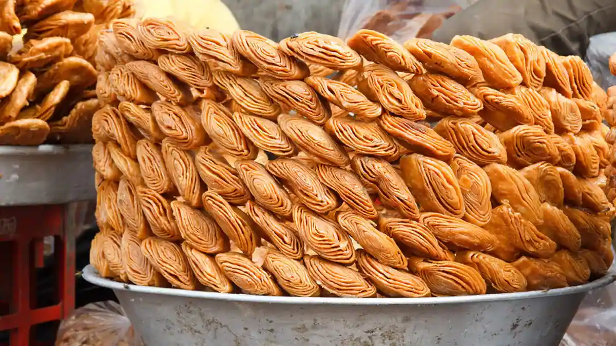 Assorted Khaja arranged in a decorative pattern, featuring variations like chocolate-infused, nut-studded, and fruity-flavored, highlighting the versatility and modern twists on the classic snack.