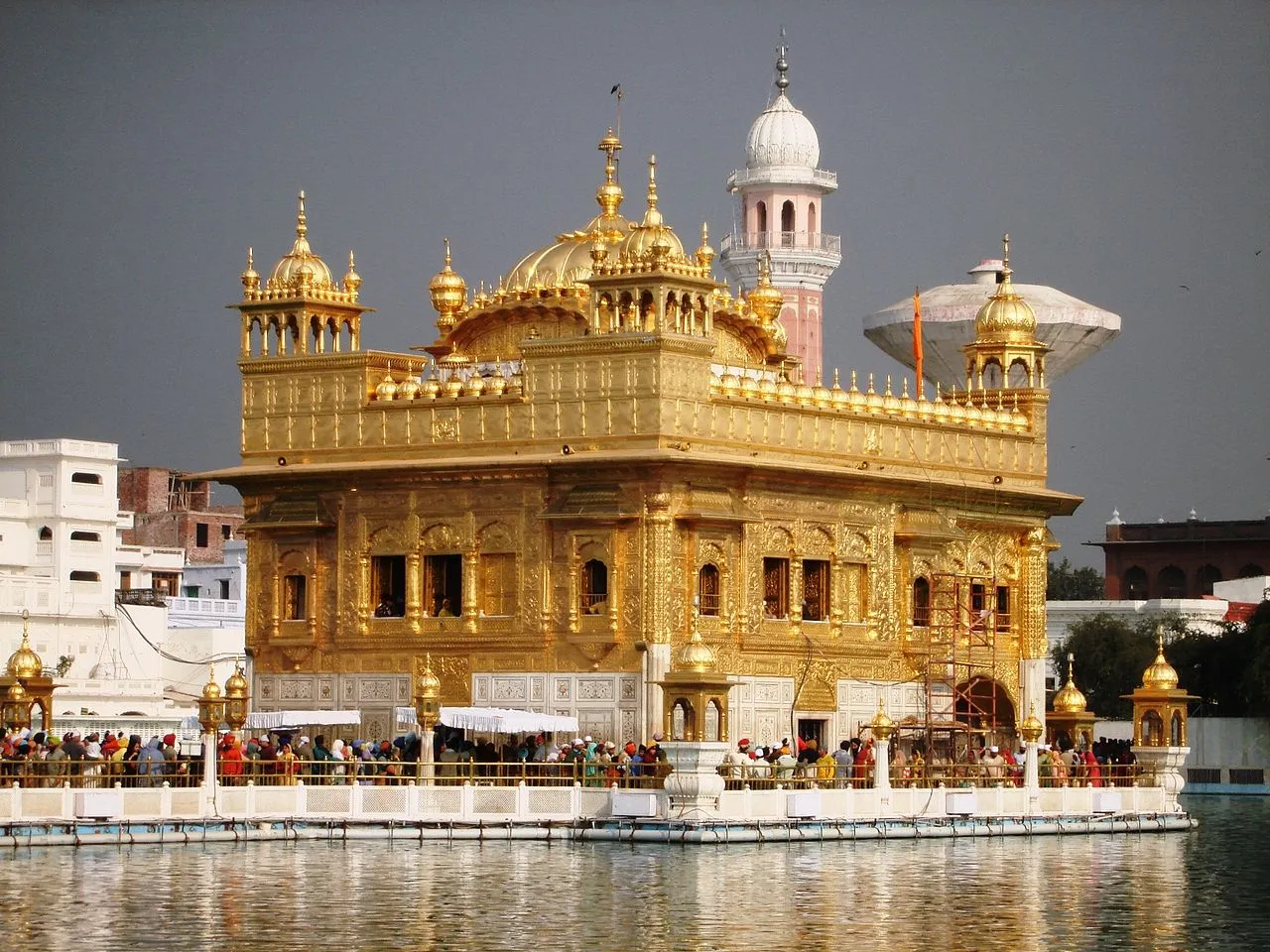 Sikh devotees engaged in seva, serving meals in the Langar Hall of the Golden Temple complex