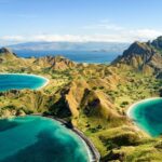 Pemandangan spektakuler dari puncak bukit Pulau Padar, menampilkan tiga teluk dengan pasir berwarna-warni