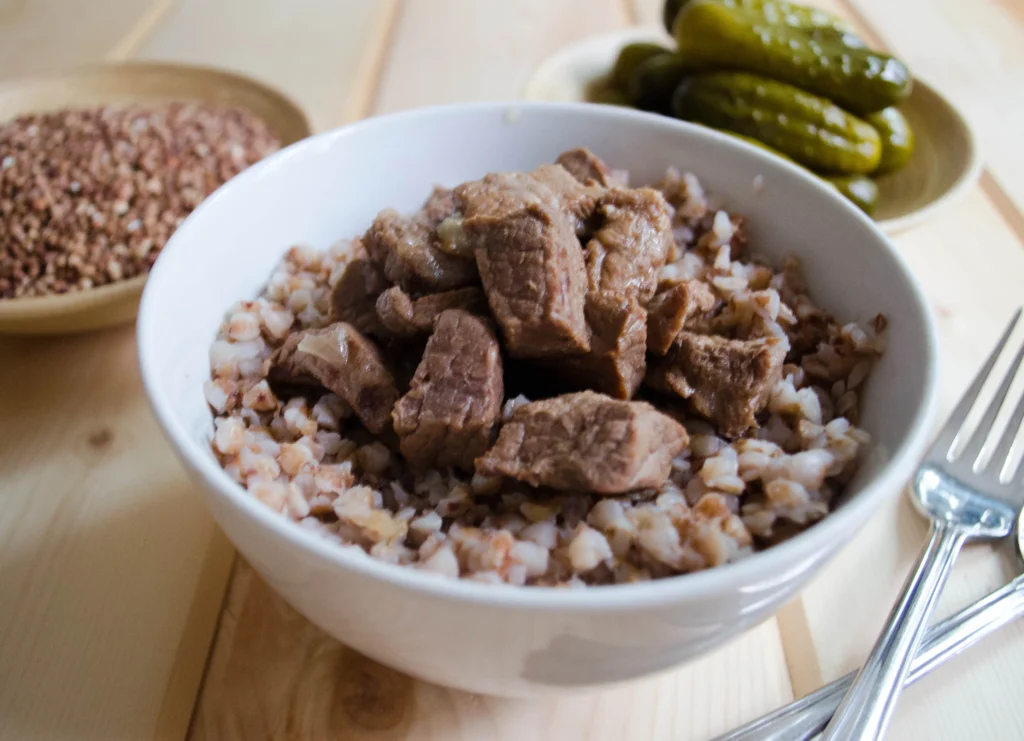 A bowl of cooked kasha (roasted buckwheat groats) with fresh herbs.