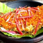 Hidangan arsik ikan mas khas Batak dengan bumbu rempah lengkap dan warna kuning keemasan yang menggugah selera